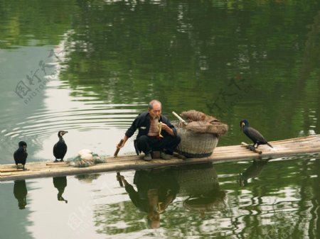 蹲在木筏上吃粽子的老渔翁图片