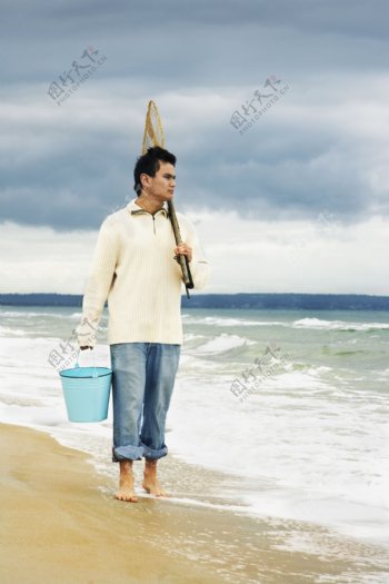 海边捕鱼的男人图片