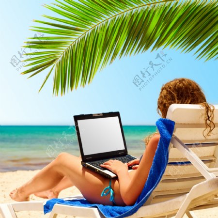 沙滩海滩笔记本电脑上网冲浪的美女图片