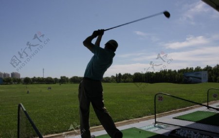 高尔夫练习场练球的男人图片