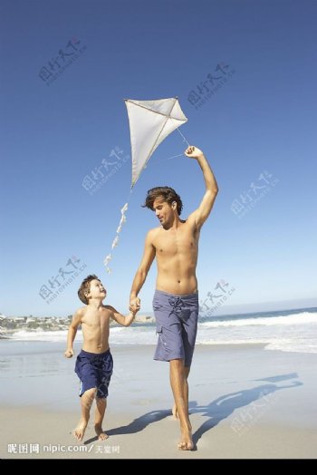 海边放风筝的父子俩