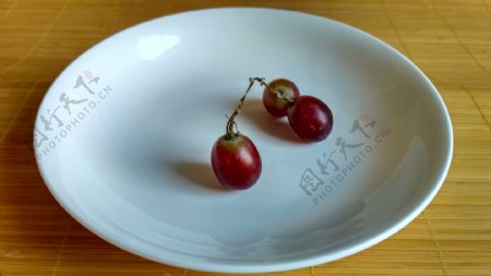 白色碟子上的三颗红葡萄