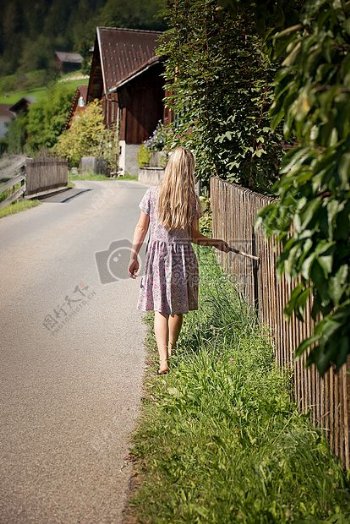 女孩在白色和紫色长裙白天路上行走绿草场