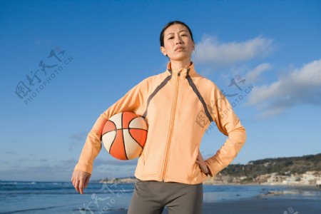 海边拿篮球的女人图片