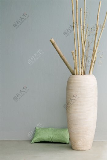 装有竹竿的花盆旁的枕头图片