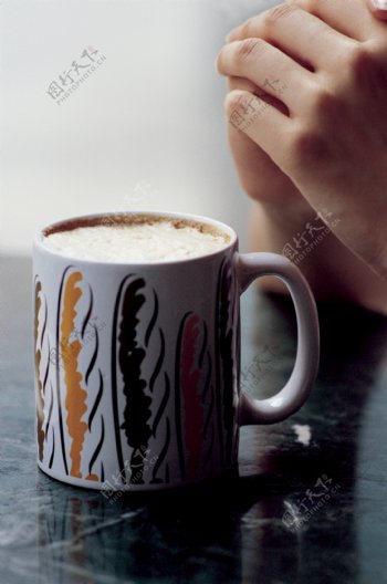 一杯奶茶旁的双手图片