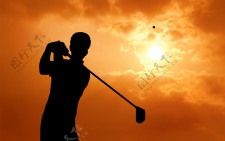 夕阳下挥动高尔夫球的男人