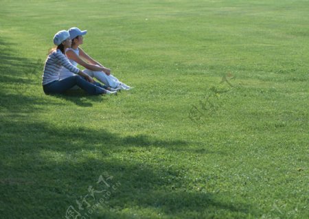 坐在草地上的两个美女图片