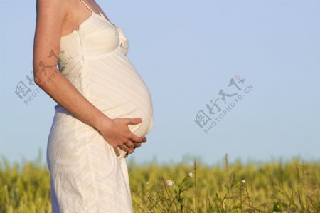 草地上摸肚子的孕妇图片