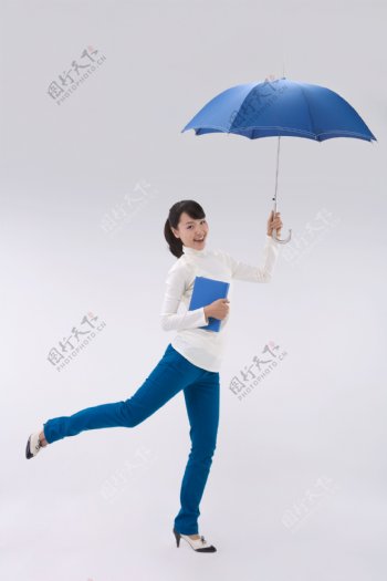 拿着一本书和雨伞的开心女孩图片