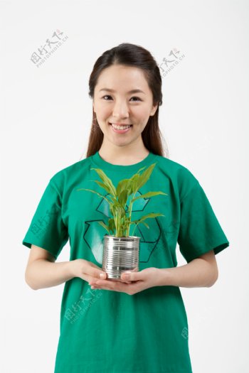 双手捧着植物的环保志愿者美女图片