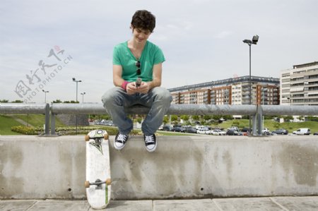 玩手机的滑板青年图片