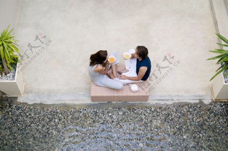 坐着大水池旁喝茶的外国情侣图片