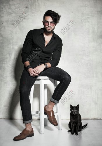 坐在凳子上的时尚男人和猫图片