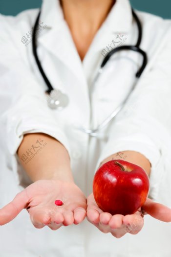 医生手里的药片和苹果图片