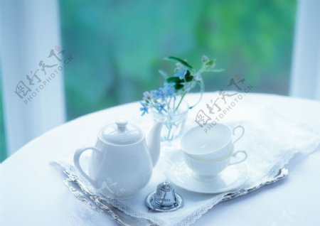 室内圆桌上的茶杯茶壶鲜花图片