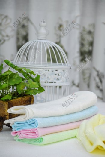 白色鸟笼前放着的彩色毛巾图片