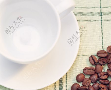 咖啡豆与咖啡杯在淡绿色桌面上的构图