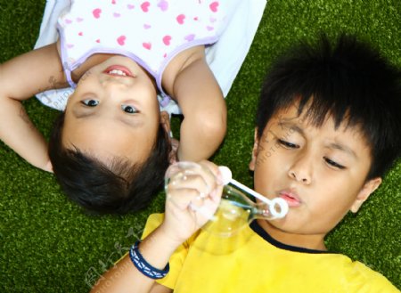 两个孩子躺在草地上玩耍