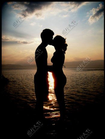 夕阳海水中的情侣图片