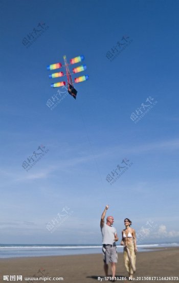 海边放风筝的情侣图片