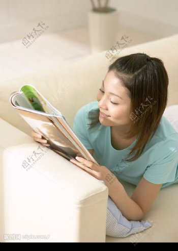 趴在沙发上看书的女子图片