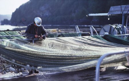 海边修补渔网的渔民图片