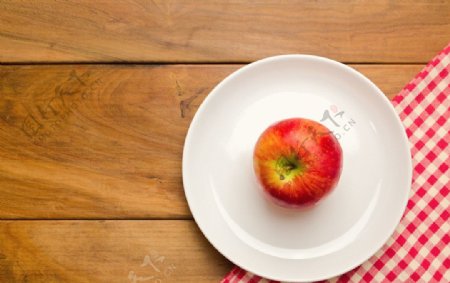 木桌餐盘里的红苹果图片