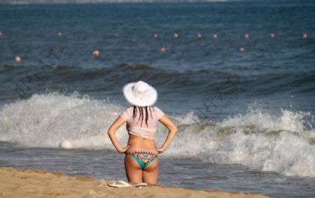 沙滩上带帽子的女性图片