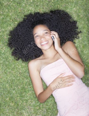 躺在草地上打电话的少女图片