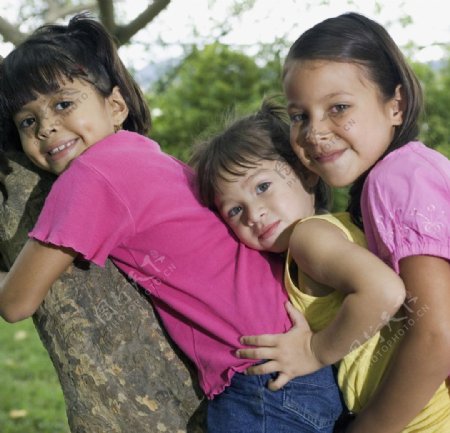 抱着树快乐玩耍的姐妹图片
