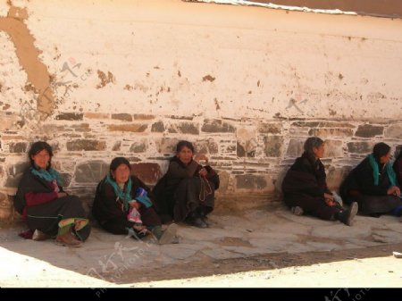 拉卜楞寺高墙下坐着的喇嘛教信徒们图片