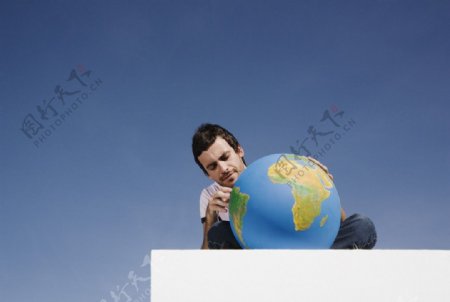 玩地球模型的男人图片