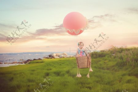 绿色草地乘着气球的孩子图片
