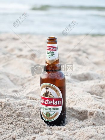 放在沙滩上的啤酒瓶