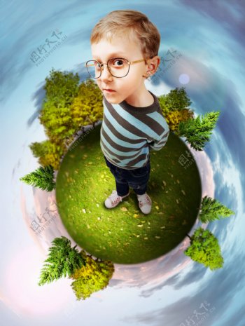 站在绿色地球上的小男孩图片
