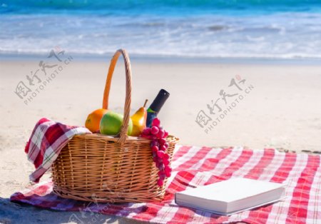 沙滩上的竹篮与书本图片