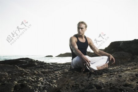 坐在岩石上的男人图片