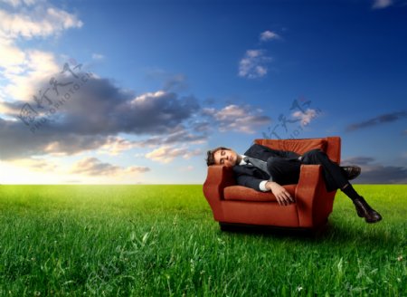 草地上躺在沙发睡觉的男子图片