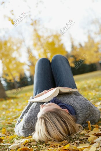 拿书本躺在草地上的美女图片