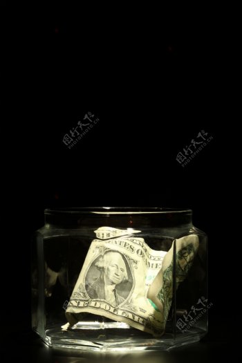 透明玻璃瓶里的美元图片