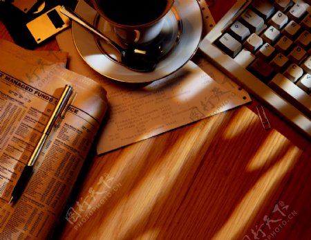 办公桌上的钢笔报纸咖啡杯税单等等图片