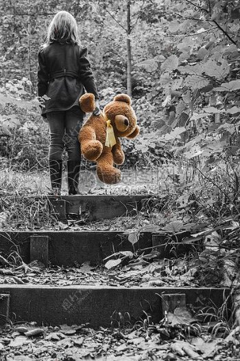 女孩夹克携带棕熊毛绒玩具选择性彩色照片