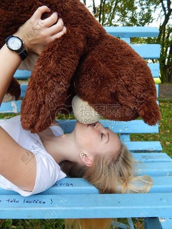 姑娘亲吻一个玩具熊