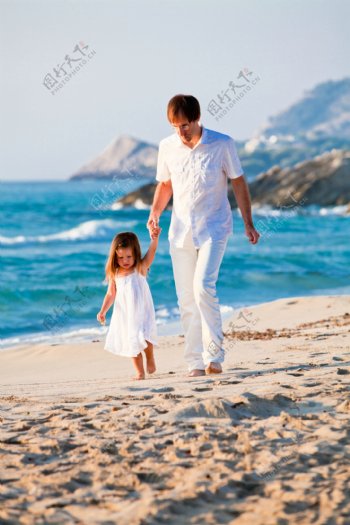 沙滩上领着孩子的爸爸图片