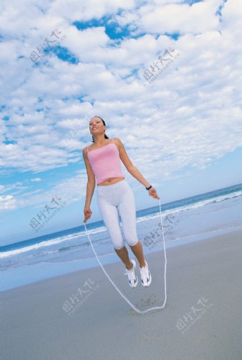 海滩上跳绳的美女图片