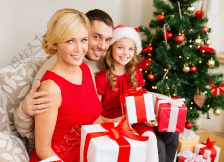 拿着礼物的家庭与圣诞树图片