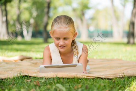 躺在草地上玩电脑的女孩图片