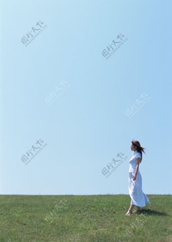 行走在草地上的女人图片