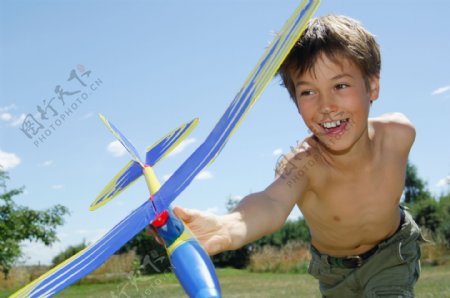 草地上玩飞机的儿童图片